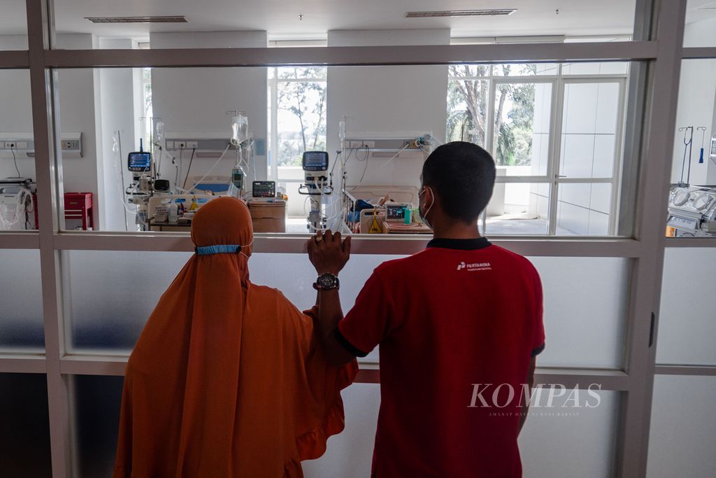 Pasangan suami istri, Eva Nurmala (34) dan Lamhari (39), melihat anak ketiga mereka, Nasifa (2,8), dari balik kaca di ruang pediatric intensive care unit (PICU) atau ruang perawatan intensif khusus anak di Rumah Sakit Badan Pengusahaan Batam, Kota Batam, Kepulauan Riau, Kamis (27/10/2022). 