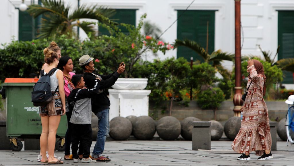 Turis asing menikmati wisata di kawasan Kota Tua, Jakarta Barat, Kamis (5/3/2020). Pelaku usaha pariwisata berharap kasus positif Covid-19 tidak signifikan memengaruhi daya tarik wisatawan asing berkunjung ke Jakarta. 
