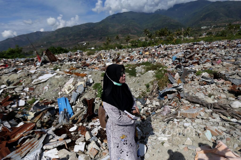 Muna, Sabtu (28/9/2019), berdoa saat mengunjungi bekas rumahnya di Perumnas Balaroa, Palu, Sulawesi Tengah, yang masih porak poranda akibat likuefaksi yang dipicu oleh gempa. Muna kehilangan suami dan dua orang anaknya pada peristiwa tersebut.