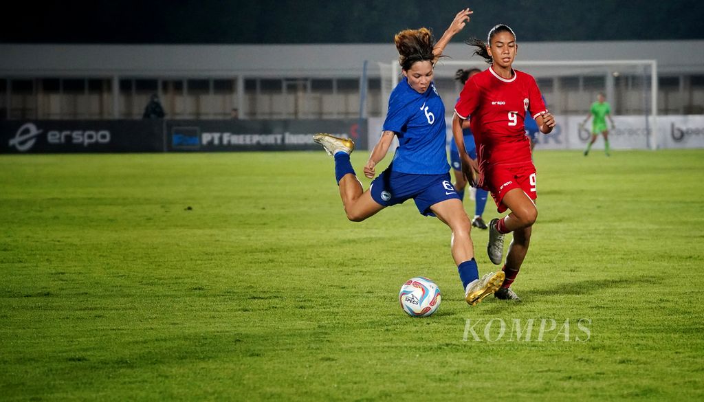 Striker timnas putri Indonesia Claudia Alexandra Scheunemann (kanan) mengawal striker Singapura Nur Farhanah Binte Ruhaizat dalam laga persahabatan di Stadion Madya, Kompleks Gelora Bung Karno, Jakarta, Selasa (28/5/2024).