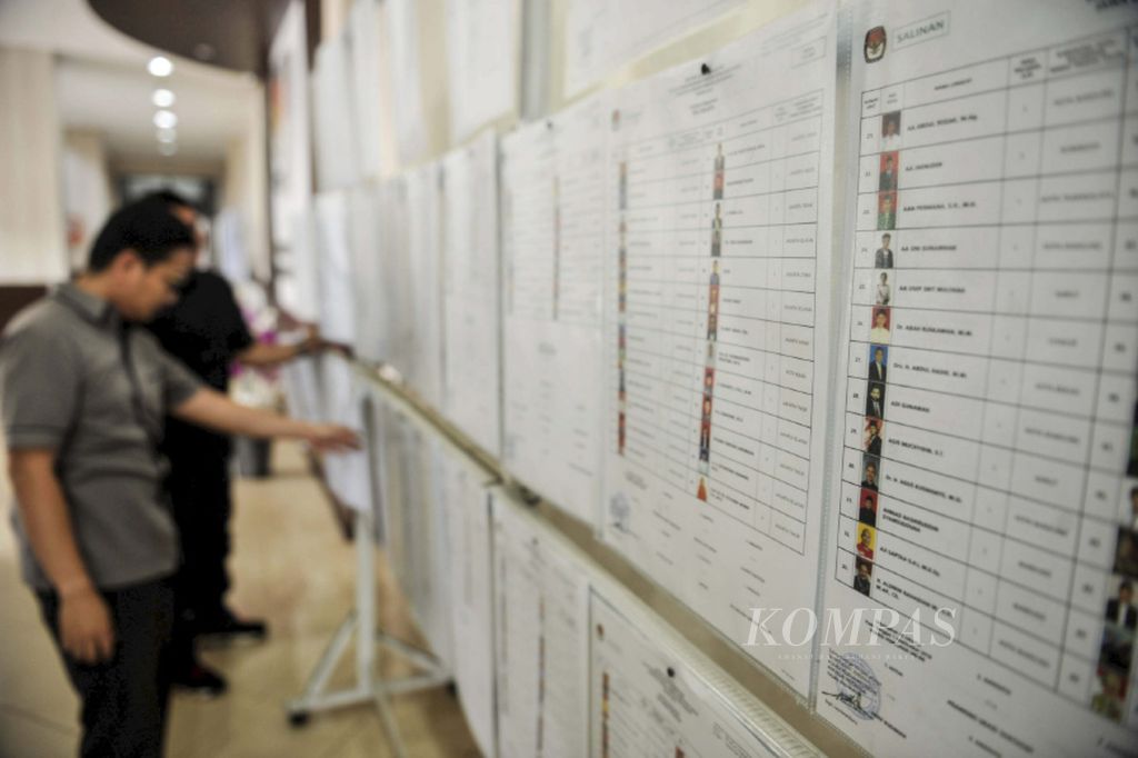 Petugas Komisi Pemilihan Umum mengamati daftar calon sementara anggota DPR di kantor KPU, Jakarta, Rabu (19/9/2018). Penetapan bakal caleg DPR, DPRD, dan DPD, hingga bakal capres-cawapres akan diumumkan pada Kamis (20/9/2018).
