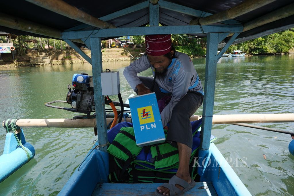 Nelayan bersiap memasang baterai baru untuk perahu motor listriknya di kawasan wisata Green Canyon, Desa Kertayasa, Kecamatan Cijulang, Kabupaten Pangandaran, Jawa Barat, Minggu (5/5/2024). 