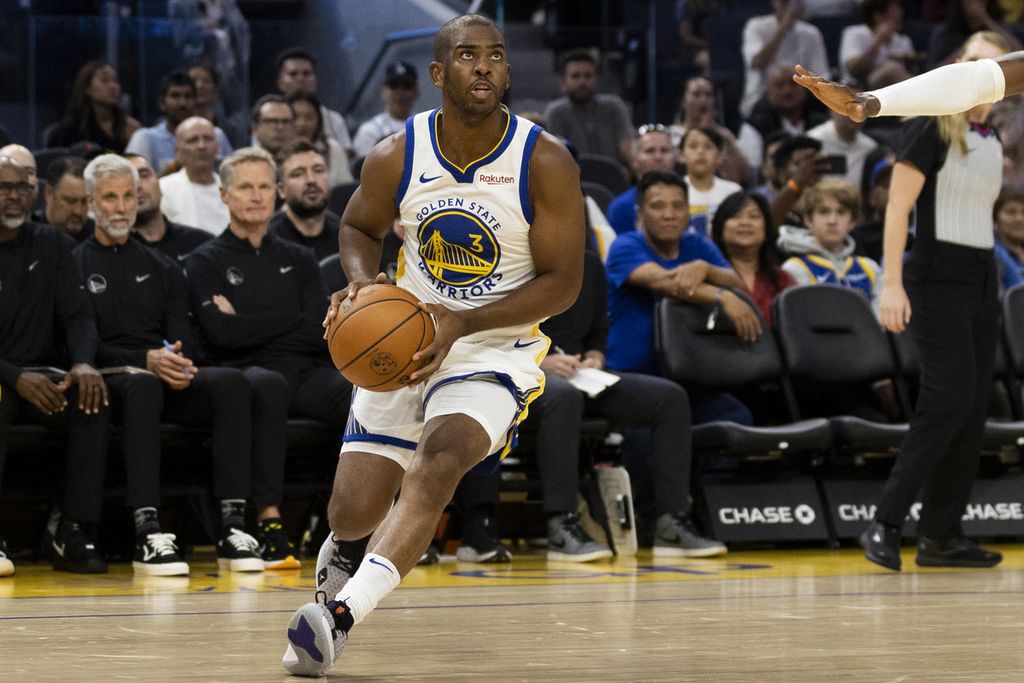 Pemain Golden State Warriors, <i>guard </i>Chris Paul, membawa bola saat melawan Los Angeles Lakers pada laga NBA di Chase Center, San Francisco, Minggu (8/10/2023).