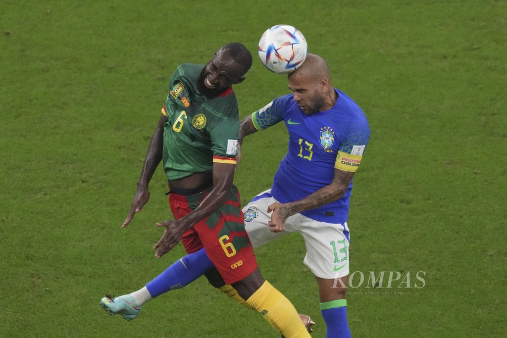Kapten Brasil Dani Alves (kanan) berebut bola dengan pemain Kamerun Nicolas Moumi Ngamaleu dalam pertandingan terakhir Grup G di Stadion Lusail, Qatar, Sabtu (3/12/2022) dini hari WIB. Brasil yang menurunkan pemain lapis kedua kalah oleh Kamerun 1-0. Meski menang, Kamerun gagal melaju ke babak 16 besar. Brasil lolos bersama Swiss yang di saat bersamaan menang 3-2 atas Serbia.