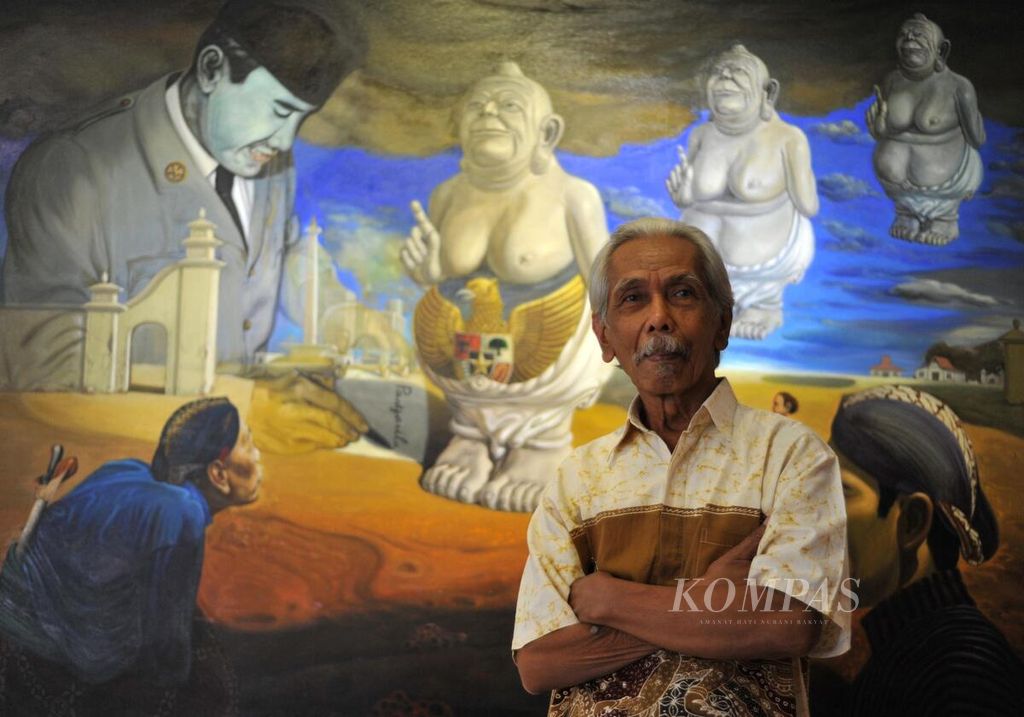 Pelukis VA Sudiro berpose di depan lukisan karyanya, Melahirkan Pancasila", pada tahun 2016. 