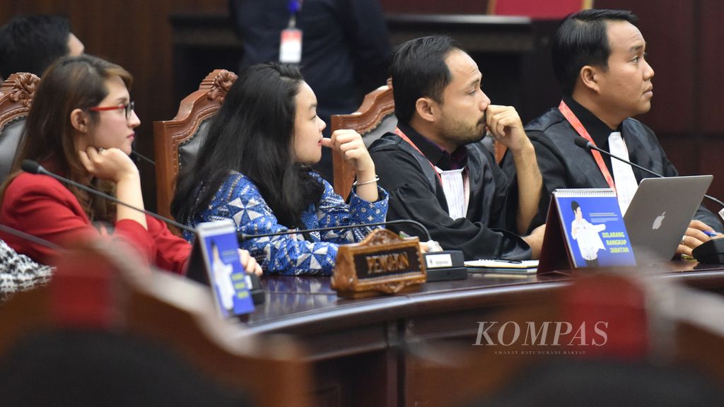 Kuasa hukum pemohon dalam sidang putusan perkara nomor 56/PUU-XVII/2019 Donal Fariz (dua kanan) dan Fadli Ramadhanil (kanan) menyimak pembacaan putusan yang disampaikan Ketua Mahkamah Konstitusi (MK) Anwar Usman di Gedung MK, Jakarta, Rabu (11/12/2019). Dalam sidang itu, MK mengabulkan sebagian permohonan pengujian Undang-Undang Nomor 1 Tahun 2014 tentang Pemilihan Gubernur, Bupati, dan Wali Kota yang diajukan oleh dua lembaga swadaya masyarakat Perkumpulan untuk Pemilu dan Demokrasi (Perludem) dan Indonesia Corruption Watch (ICW). MK menyatakan bahwa mantan narapidana harus menunggu selama lima tahun setelah bebas jika ingin maju dalam pilkada.