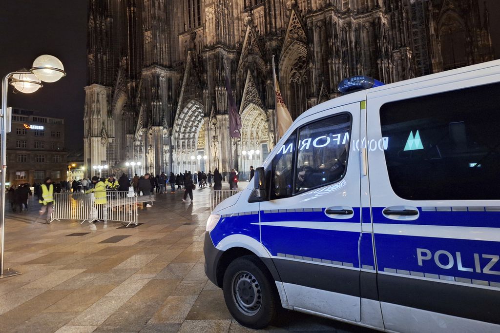 Sebuah kendaraan polisi diparkir di depan katedral di Koeln, Jerman, Sabtu (23/12/2023). Kepolisian setempat mendapat informasi kemungkinan serangan ke katedral itu. 