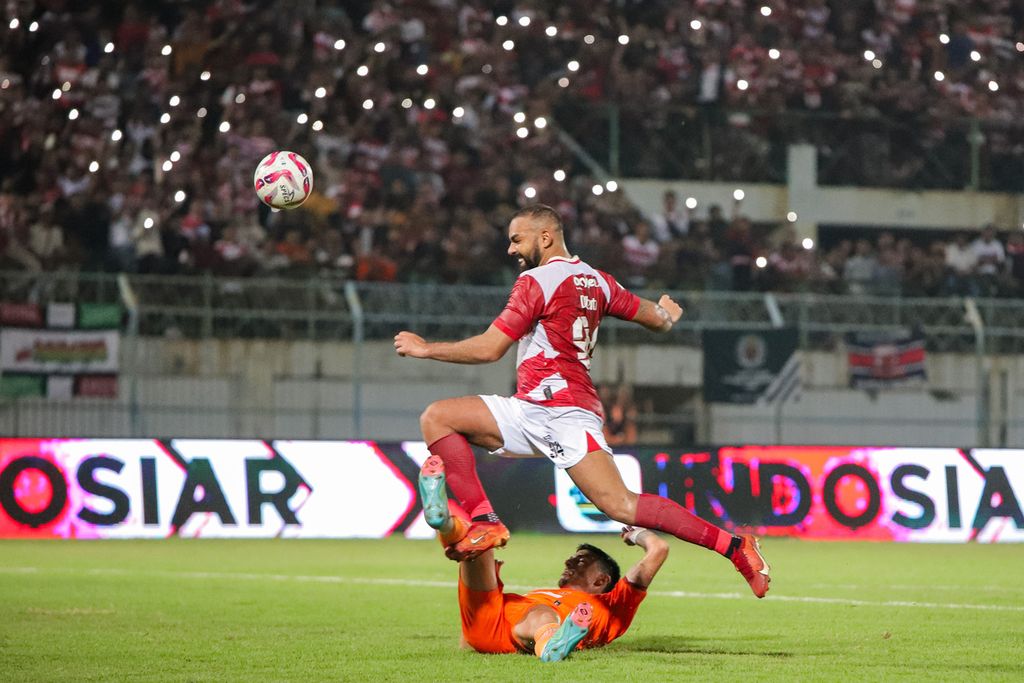Pemain Madura United Dalberto Luan Belo (atas) menendang bola dengan dihadang pemain Borneo FC, Silverio Junio Goncalves, pada pertama semifinal Championship Series Liga 1 di Stadion Gelora Bangkalan, Rabu (15/5/2024). 