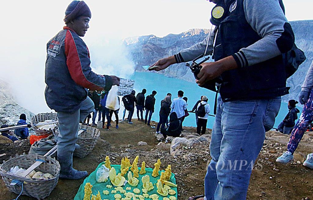 Petambang menjajakan suvenir belerang kepada pengunjung di sekitar Kawah Ijen, Banyuwangi, Jumat (30/6). Pengunjung menghabiskan waktu libur Lebaran untuk melihat fenomena api biru di Kawah Ijen.