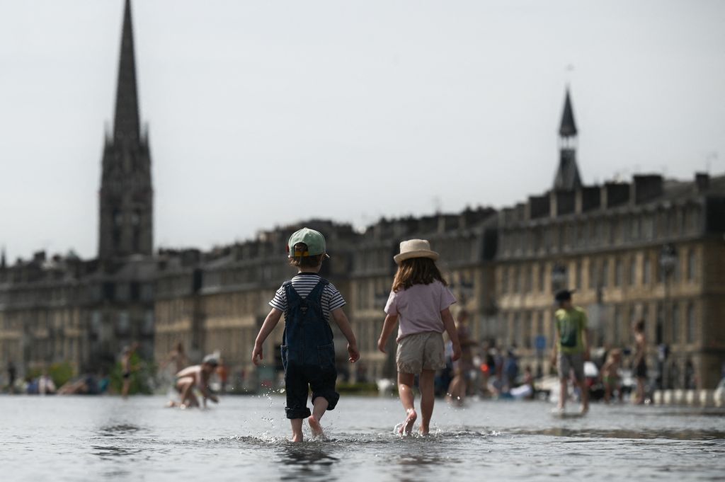 Anak-anak bermain air di fitur "Miroir d'Eau" (Air Pantul) di Bordeaux, Perancis, 18 Mei 2022, saat gelombang panas melanda negara itu.