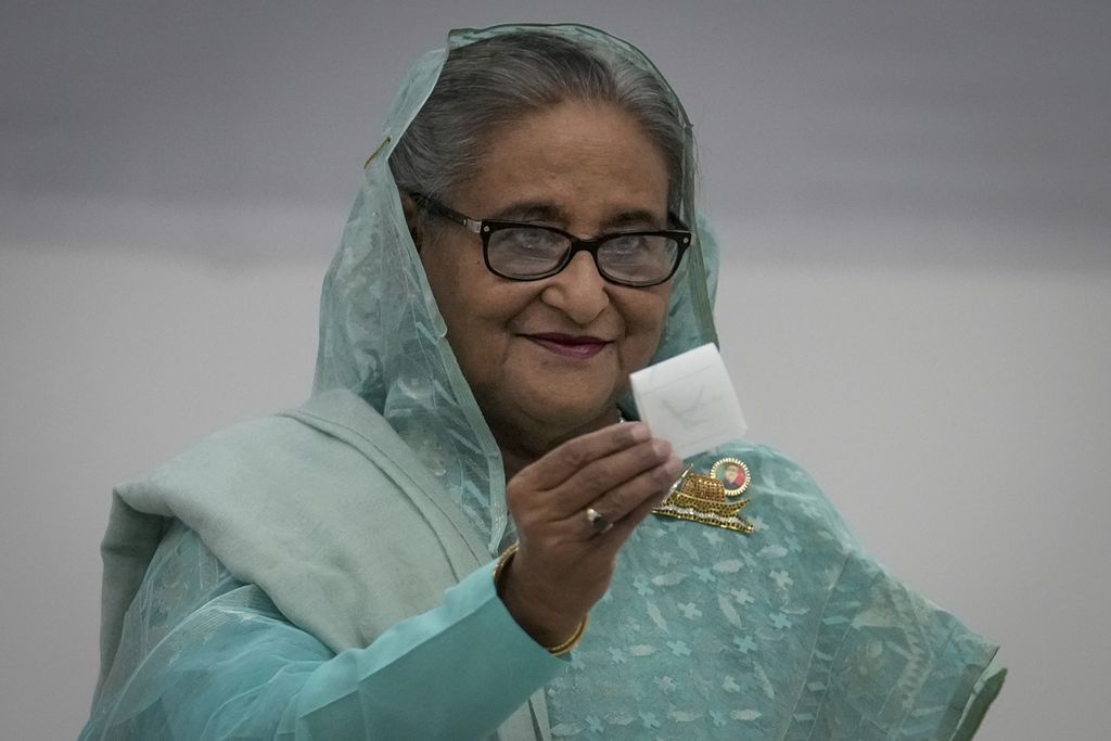 Perdana Menteri Bangladesh Sheikh Hasina menunjukkan kertas suaranya saat memberikan suara di Dhaka, Bangladesh, 7 Januari 2024. Sekitar 80 persen negara menggelar pemilu tahun 2024 ini sehingga memengaruhi kebijakan ekonomi global. 