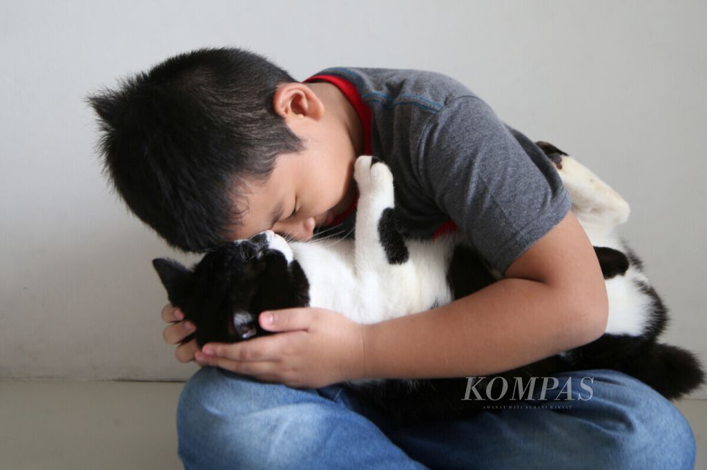 Abraham Mangkudijaya bersama Momo, kucing kesayangannya, bermain-main di ruamahnya di kawasan Cinangka, Depok, Jawa Barat, Jumat (11/12/2020). 