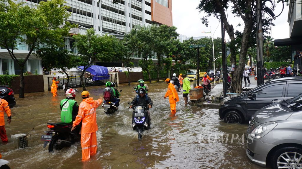 Petugas membantu kendaraan melewati banjir di Jalan Kemang Raya, Mampang Prapatan, Jakarta Selatan, Selasa (25/2/2020). Hingga Selasa siang, banjir dengan ketinggian sekitar 50 cm itu belum surut.