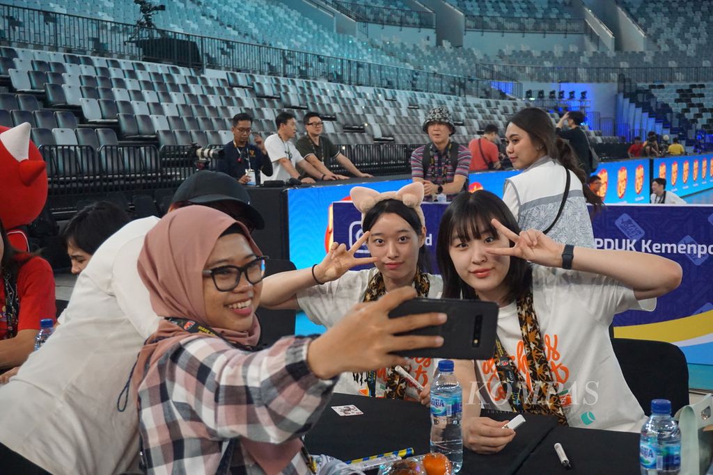 Penggemar berswafoto dengan pemain Daejeon Jung Kwan Jang Red Sparks dalam acara tanda tangan (<i>fansign</i>) bersama di Stadion Indonesia Arena, Sabtu (20/4/2024). Kegiatan ini merupakan rangkaian acara laga ekshibisi antara timnas Indonesia dan Red Sparks yang bertajuk “Fun Volleyball”.