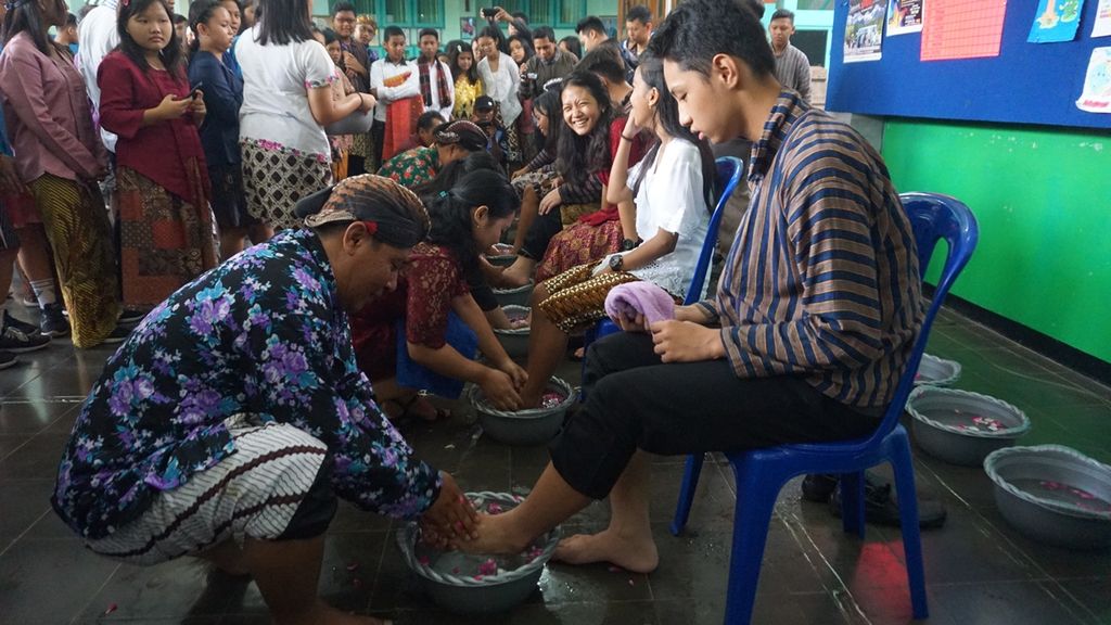 Guru membasuh kaki muridnya di SMP Pius, Cilacap, Jawa Tengah, Senin (25/11/2019). Guru dan murid bergantian membasuh kaki dalam peringatan Hari Guru Nasional sebagai simbol kerendahan hati dan saling menghormati.