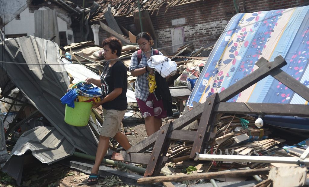 Warga membawa barang-barang dari rumahnya yang rusak oleh angin kencang di Desa Sidokepung, Kecamatan Buduran, Sidoarjo, Jawa Timur, Senin (24/10/2022). Hujan disertai angin kencang yang melanda pada sore sehari sebelumnya di Sidoarjo menyebabkan ratusan rumah rusak di empat desa di tiga kecamatan.