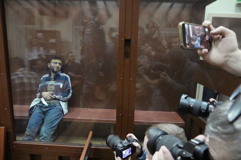 Para pewarta foto mengambil gambar Dalerdzhon Mirzoyev, salah satu terduga pelaku penembakan di Balai Kota Crocus di Moskwa, Rusia, saat menjalani sidang awal di Pengadilan Distrik Basmanny, Moskwa, Minggu (24/3/2024).