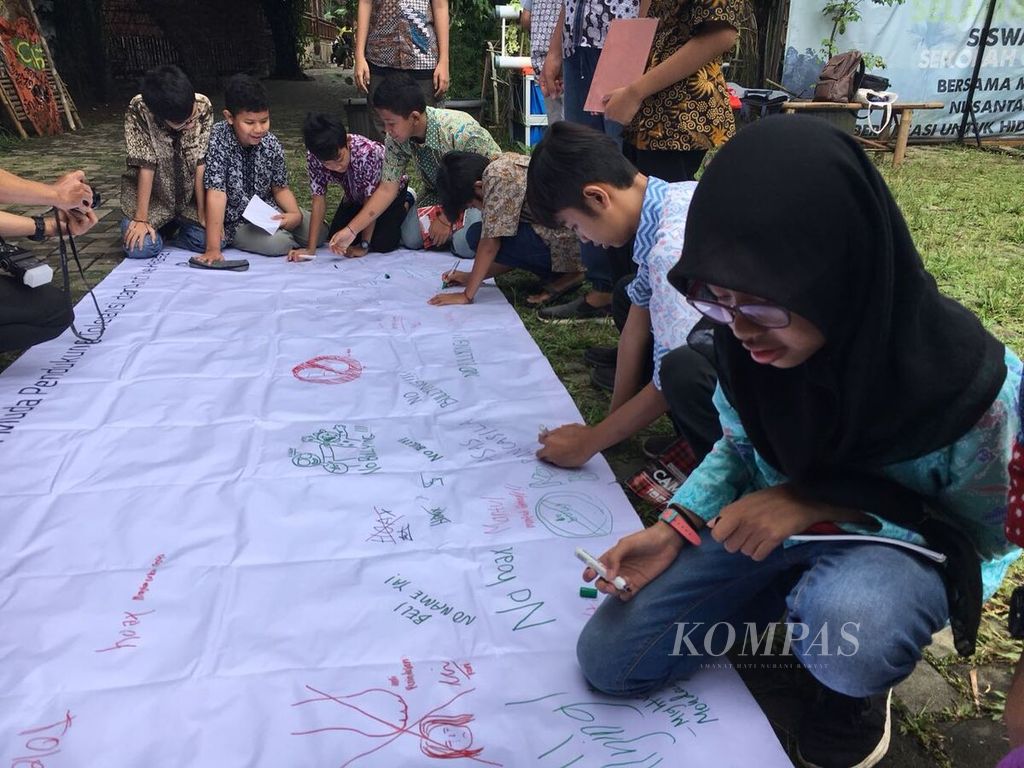 Siswa-siswi Sekolah Citra Alam menggambarkan dan menuliskan pendapat mereka terkait kondisi kekerasan dan intoleransi pada sebuah spanduk dalam acara "Deklarasi Sekolah Gempita" di Sekolah Citra Alam, Jagakarsa, Jakarta Selatan, Senin (12/3).