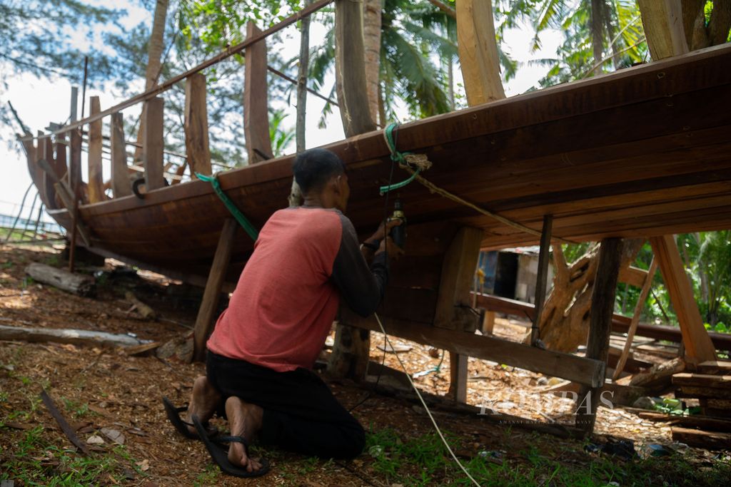 Zulkifli (51) membuat perahu kayu nelayan atau disebut juga pompong, berukuran 4 groston di Desa Kelanga, Kecamatan Bunguran Timur Laut, Kabupaten Natuna, Kepulauan Riau, Selasa (29/3/2022).