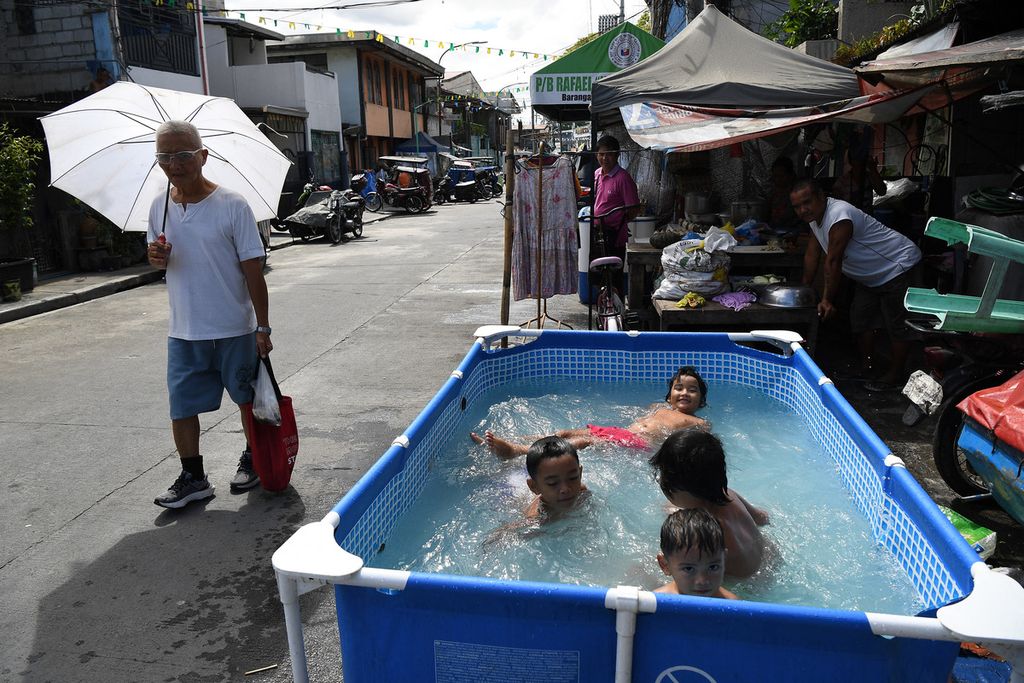 Anak-anak di Manila, Filipina, berendam untuk meredakan gerah saat suhu panas pada 3 Mei 2024.