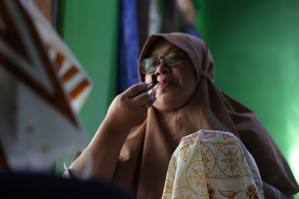 Pegiat Kelompok Batik Nitik Blawong meniup canting saat menggarap kain batik nitik di Dusun Blawong II, Desa Trimulyo, Kecamatan Jetis, Kabupaten Bantul, Daerah Istimewa Yogyakarta, Jumat (12/8/2022). 