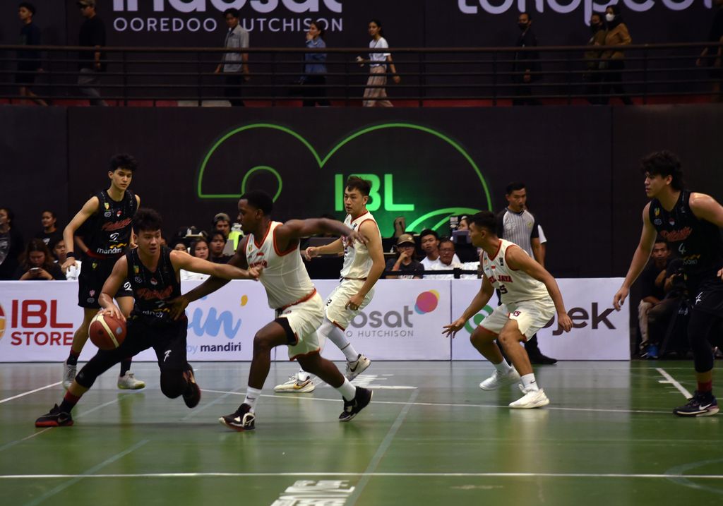 <i>Guard</i> Pelita Jaya Bakrie Jakarta, Dashaun Najee Wiggins (putih), coba mengganggu dribel <i>point guard </i>Indonesia Patriots, Greans Chandra Bartes Tangkulung, dalam laga seri keenam Liga Bola Basket Indonesia (IBL) 2023 di GOR Amongraga, Yogyakarta, Kamis (25/5/2023). 