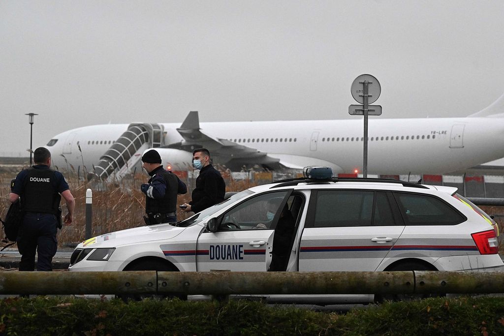 Aparat Perancis patroli dekat pesawat yang ditahan di Bandara Vatry, Champagne pada Senin (25/12/2023). Pesawat itu diduga mengangkut korban perdagangan orang.