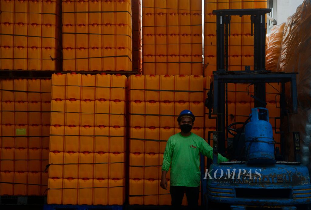 Pekerja berada di antara tumpukan jeriken yang akan diisi minyak goreng hasil pengolahan sebuah pabrik di Pelabuhan Tanjung Emas, Kota Semarang, Jawa Tengah, Selasa (29/3/2022). 
