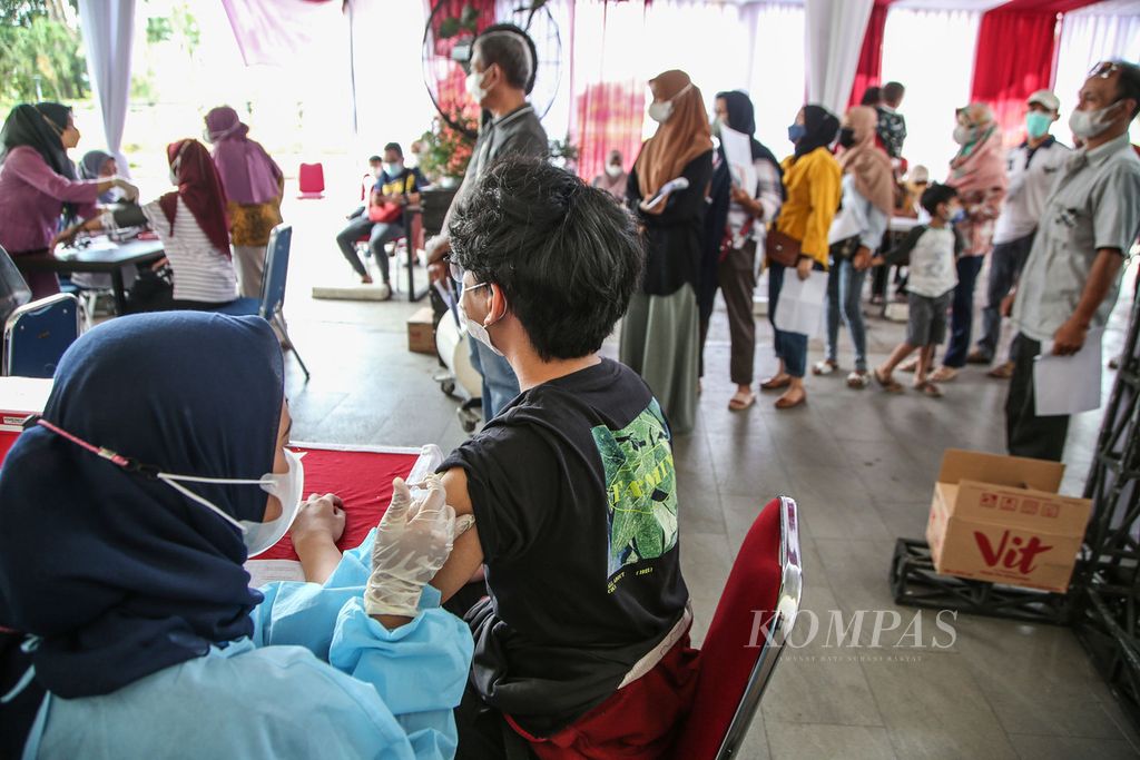 Warga memadati pelaksanaan vaksinasi merdeka <i>booster </i>di sebuah mal di kawasan Bojongsari, Depok, Jawa Barat, Selasa (29/3/2022). Vaksinasi yang diselenggarakan Kepolisian Sektor Bojongsari tersebut menyasar para pengunjung pusat perbelanjaan. Warga antusias mengikuti vaksinasi <i>booster </i>sebagai salah satu syarat perjalanan saat mudik lebaran.