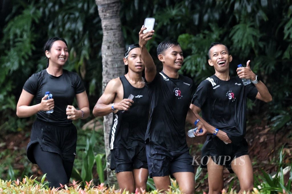 Para pelari berswafoto saat mengikuti Run the Ground di kawasan Gelora Bung Karno, Jakarta, Sabtu (9/3/2024). Harian <i>Kompas</i> dan Lembaga Penjamin Simpanan menggelar acara lari Run the Ground sebagai pra-acara Monas Half Marathon 2024.  