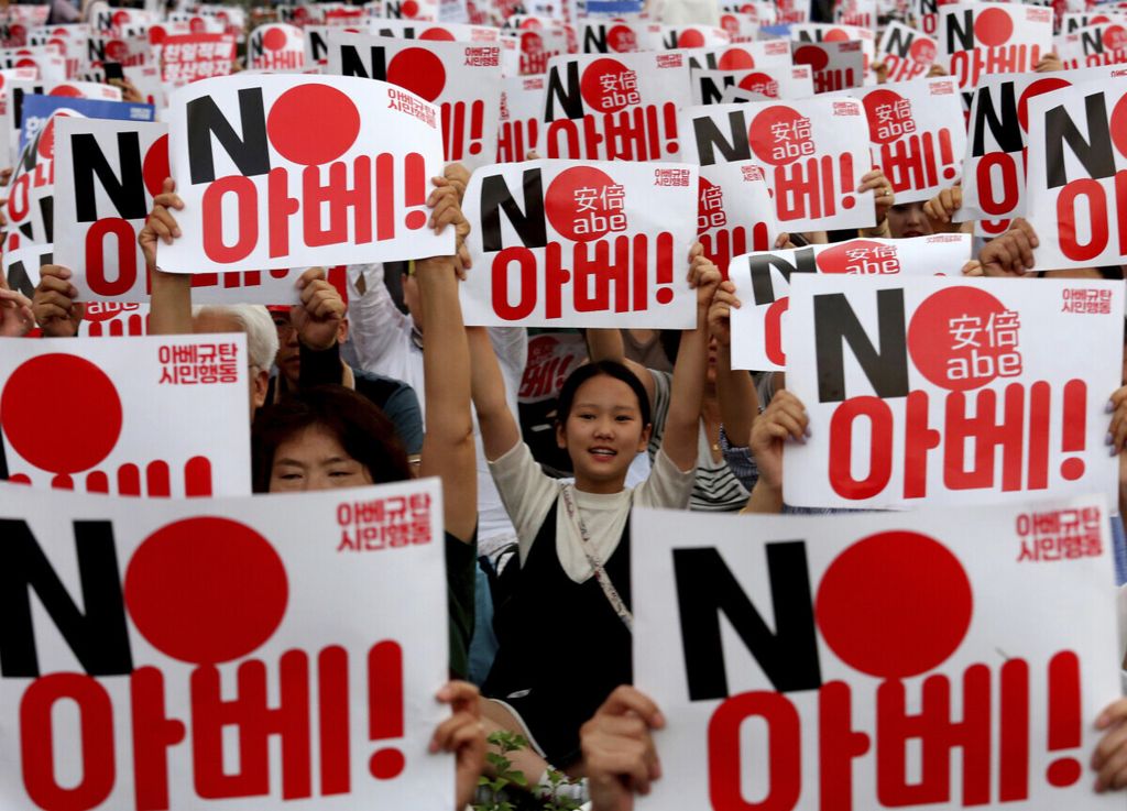 Para pengunjuk rasa Korea Selatan memegang kartu selama rapat umum untuk memperingati Hari Pembebasan Korea Selatan dari pemerintahan kolonial Jepang pada tahun 1945, di Seoul, Korea Selatan, Kamis (15/8/2019).