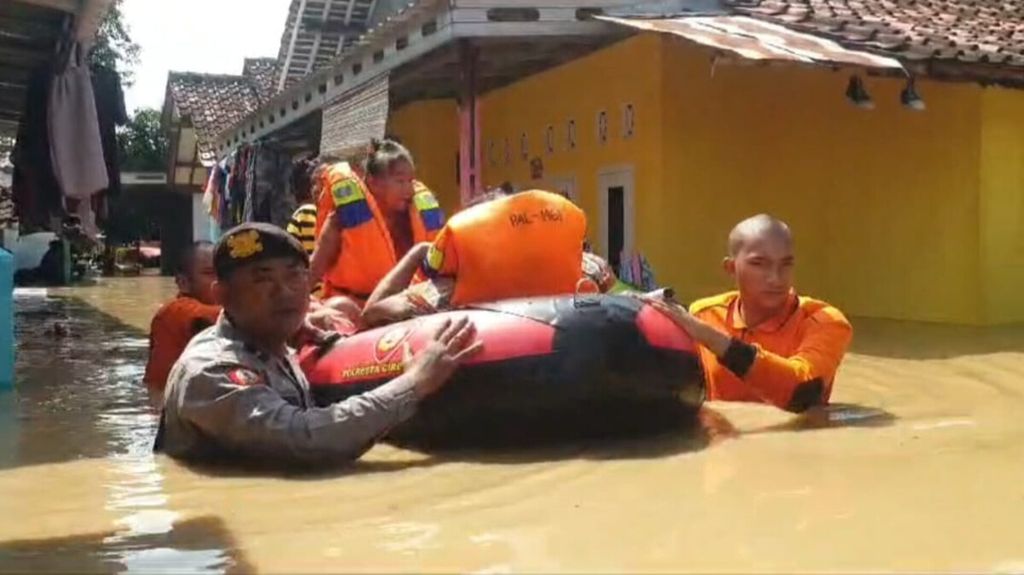 Aparat Polresta Cirebon dan petugas Badan Penanggulangan Bencana Daerah mengevakuasi warga di salah satu desa yang terdampak banjir di Kabupaten Cirebon, Jawa Barat, Rabu (6/3/2024). 