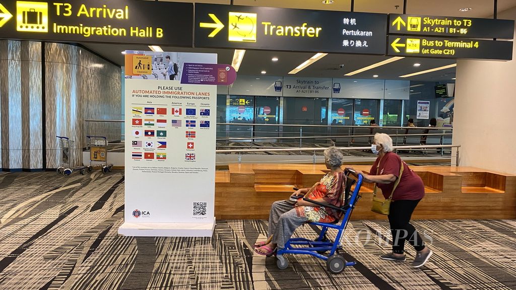 Perempuan lansia mendorong dengan kursi roda di Bandara Changi, Singapura, Rabu (20/9/2023). 