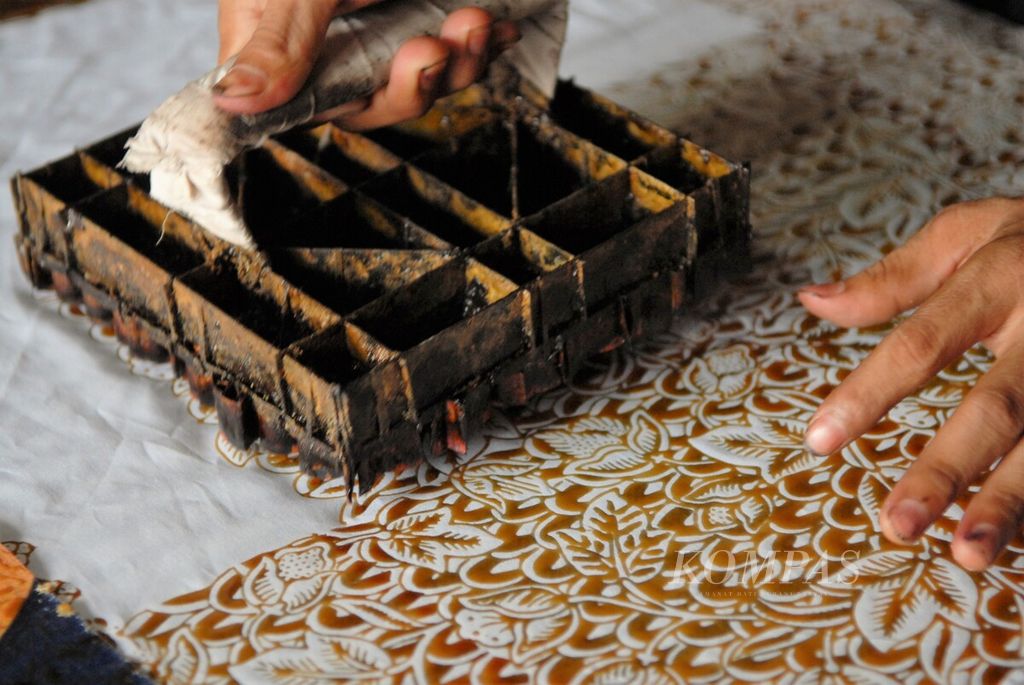 Perajin membubuhkan cap motif di atas lembaran kain di usaha kerajinan Batik Diana Jambi, Rabu (11/1/2023). Usaha batik yang semua tumbuh di kawasan Seberang Kota Jambi kini meluas ke sejumlah daerah sekitar.