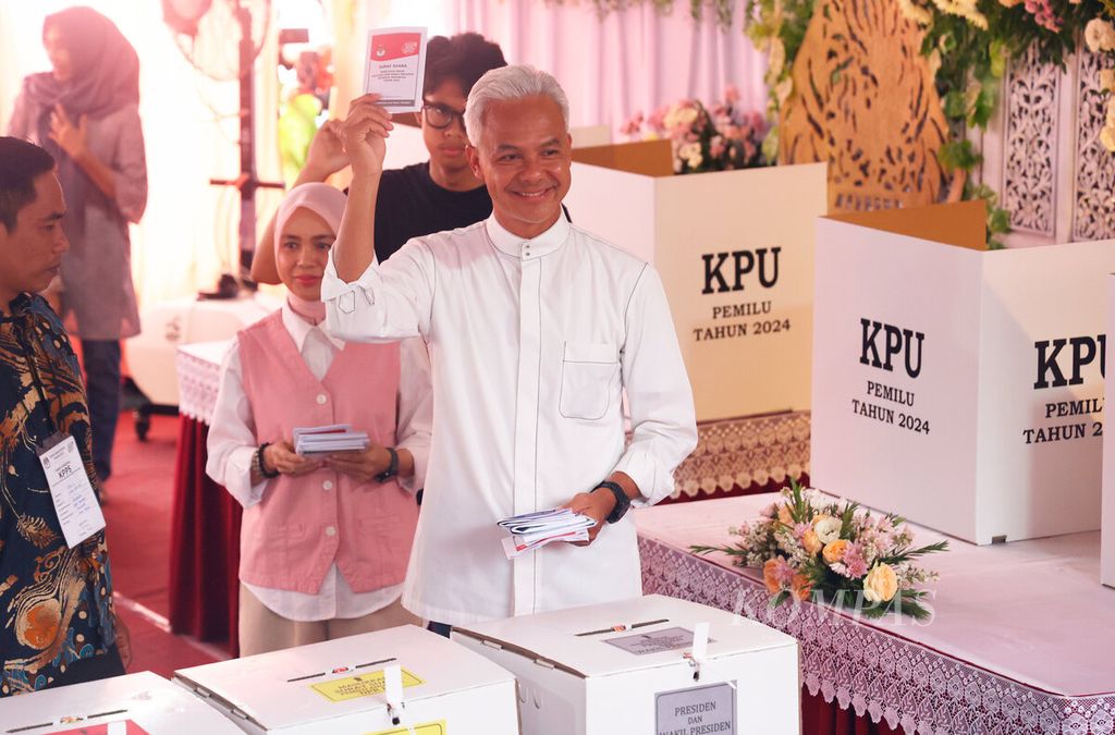 Calon presiden Ganjar Pranowo bersama istri, Siti Atikoh Suprianti, dan putranya, Muhammad Zinedine Alam Ganjar, saat memasukkan surat suara di TPS 11, Lempongsari, Kota Semarang, Jawa Tengah, Rabu (14/2/2024).