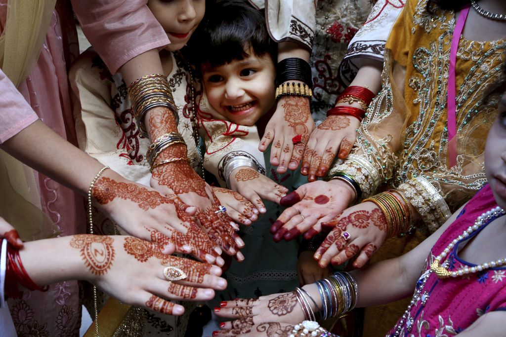 Foto yang diambil pada 13 Mei 2022 ini memperlihatkan beberapa gadis menunjukkan hena di tangan mereka sebagai bagian dari tradisi perayaan Idul Fitri di Peshawar, Pakistan. 
