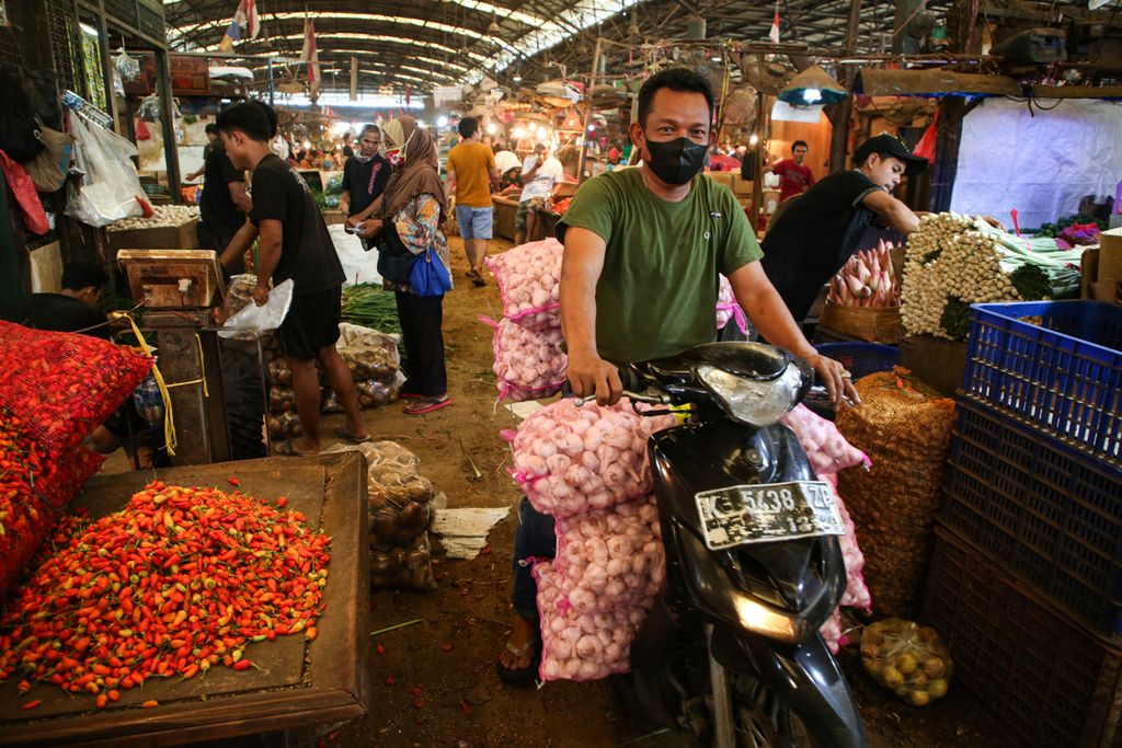 Pedagang menggunakan sepeda motor untuk menggangkut karung berisi bawang putih impor di Pasar Induk Kramat Jati, Jakarta Timur, Rabu (3/5/2023). 