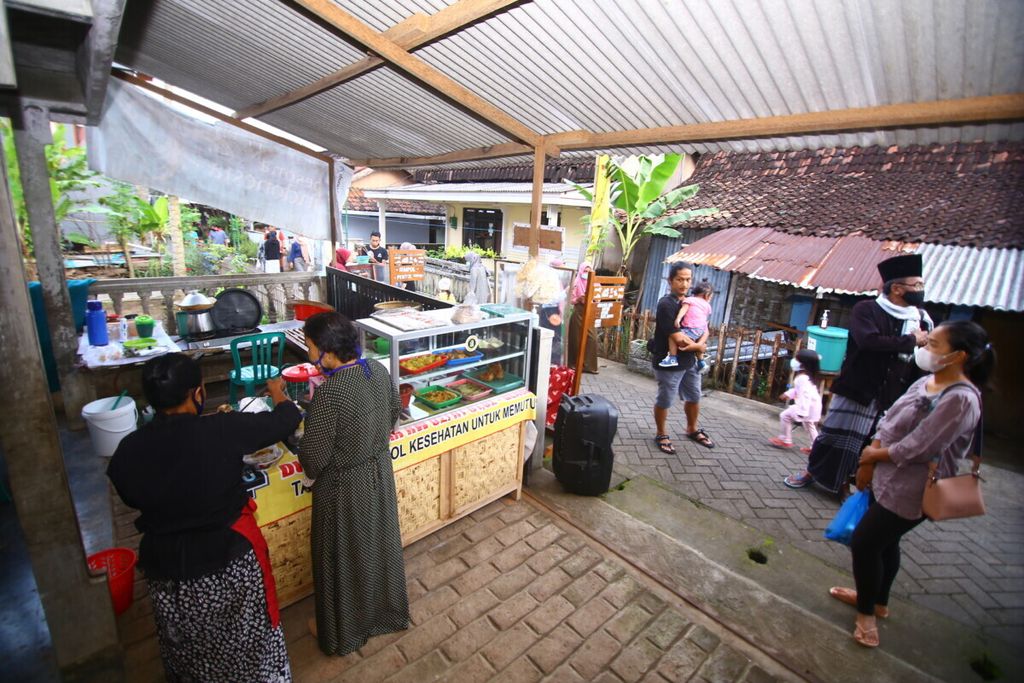Pengunjung Pasar Kampoeng Osing berbelanja aneka makanan tradisional Osing (suku asli Banyuwangi) di Pasar Kampoeng Osing, Desa Kemiren, Kecamatan Glagah, Banyuwangi, Jawa Timur, Sabtu (17/4/2021). Desa Kemiren merupakan salah satu dari 16 Desa Wisata Berkelanjutan yang dipilih oleh Kementerian Pariwisata dan Ekonomi Kreatif.