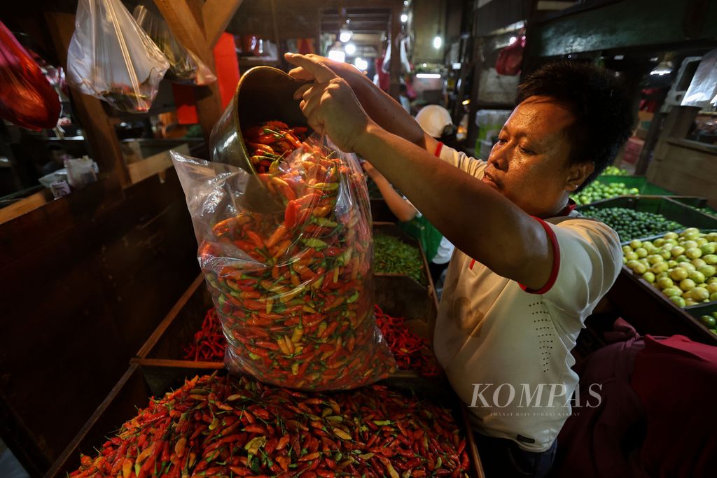 Pedagang memasukkan cabai rawit merah yang dipesan warga di Pasar Senen, Jakarta Pusat, Selasa (26/12/2023). Harga sejumlah kebutuhan pokok di Pasar Senen menurun menjelang akhir tahun.