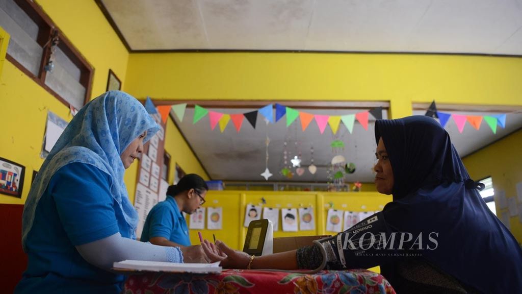 Petugas memeriksa tekanan darah warga yang mengikuti kegiatan Pos Pembinaan Terpadu untuk Penyakit Tidak Menular (Posbindu PTM) di Kelurahan Dukuh, Kecamatan Sidomukti, Kota Salatiga, Jawa Tengah,  akhir Agustus 2018.