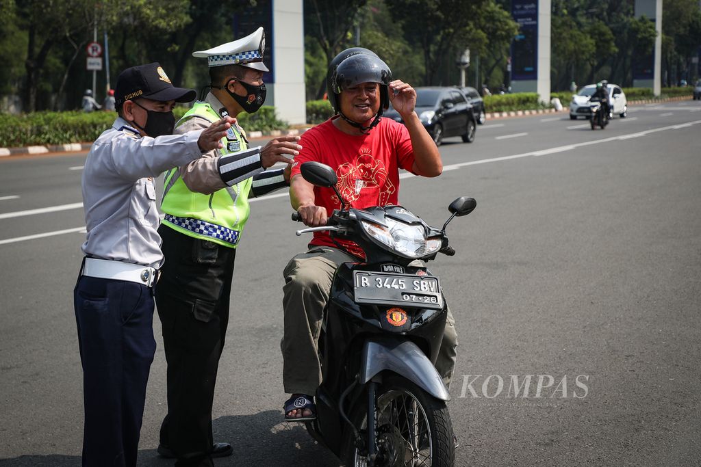 Petugas mengarahkan pengendara sepeda motor untuk menjalani uji emisi di Jalan Asia Afrika, Jakarta Pusat, Jumat (25/8/2023). 
