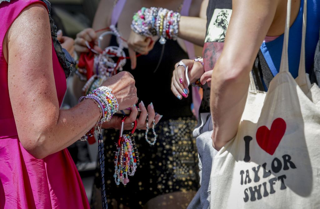 Para penggemar Taylor Swift bertukar gelang di pusat kota Vienna, Austria, Kamis (8/8/2024), setelah ancaman serangan bom dalam konser tersebut. 