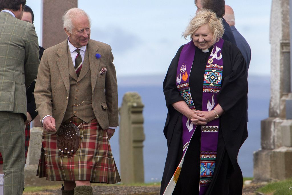 Raja Charles III (kiri) berjalan ditemani Pendeta Janet Easton Berry seusai menghadiri kebaktian Minggu di Gereja Canisbay, Caithness, Skotlandia, Minggu (4/8/2024).  