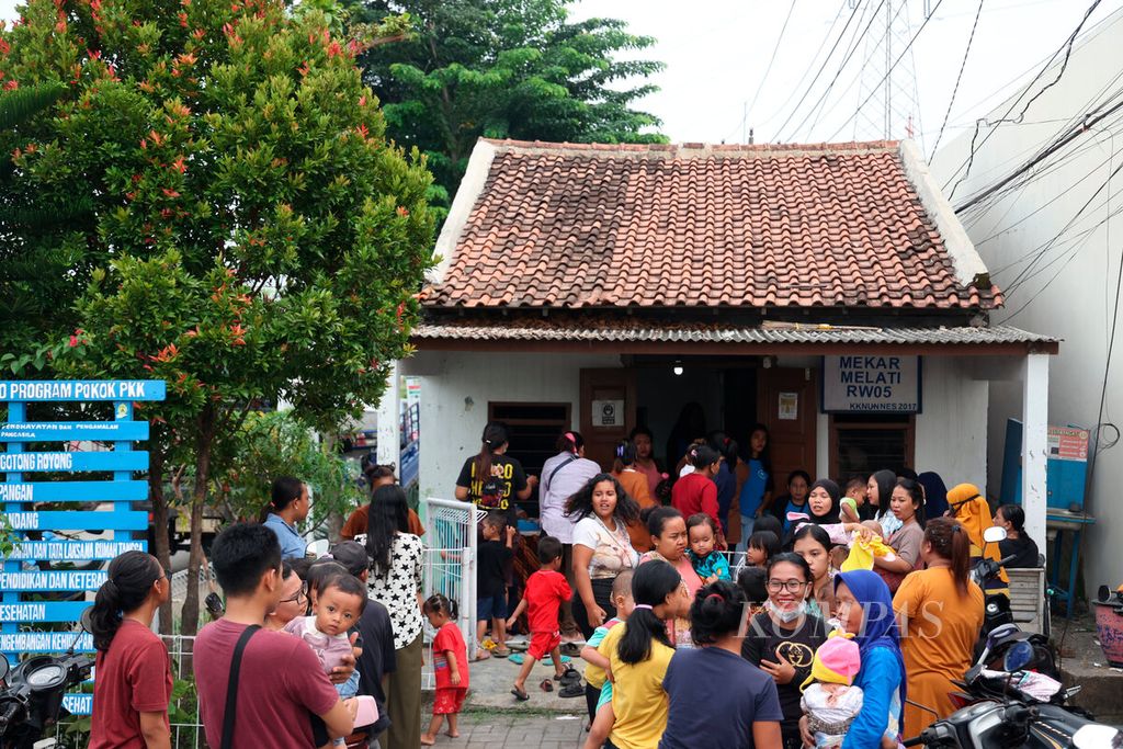 Orangtua membawa anaknya ke posyandu di Kampung Tambakrejo, Kota Semarang, Jawa Tengah, Senin (15/1/2024).  