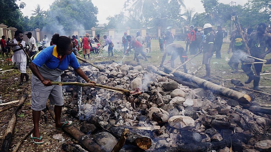 Ratusan pengungsi melakukan upacara bakar batu sebagai bentuk kekerabatan sekaligus penerimaan pemerintah kepada warga yang datang, Rabu (22/11), di halaman gedung posko pengungsian, Timika, Papua. Konflik bersenjata yang terjadi di empat kampung di Distrik Tembagapura, Timika, membuat warga harus mengungsi dan meninggalkan kampung mereka.