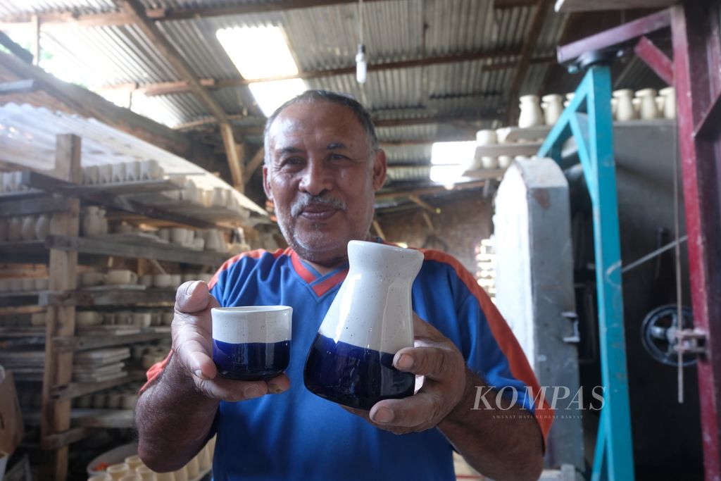 Suharto, pemilik <i>workshop </i>keramik di Kampung Dinoyo, Kota Malang, memperlihatkan cangkir keramik yang laris dipesan oleh kafe-kafe di Jakarta, Selasa (4/4/2023)
