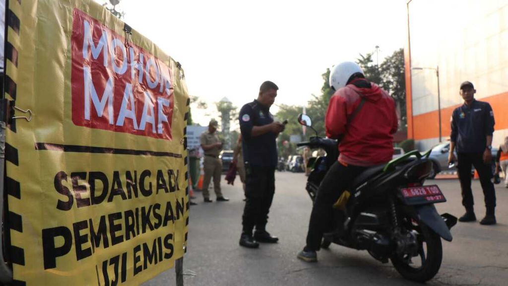 Petugas memeriksa motor yang hendak masuk kantor Dinas Lingkungan Hidup DKI Jakarta. Kebijakan larangan parkir bagi kendaraan yang belum atau tidak lulus uji emisi di lingkungan perkantoran Dinas Lingkungan Hidup DKI Jakarta dimulai pada Senin (21/8/2023).