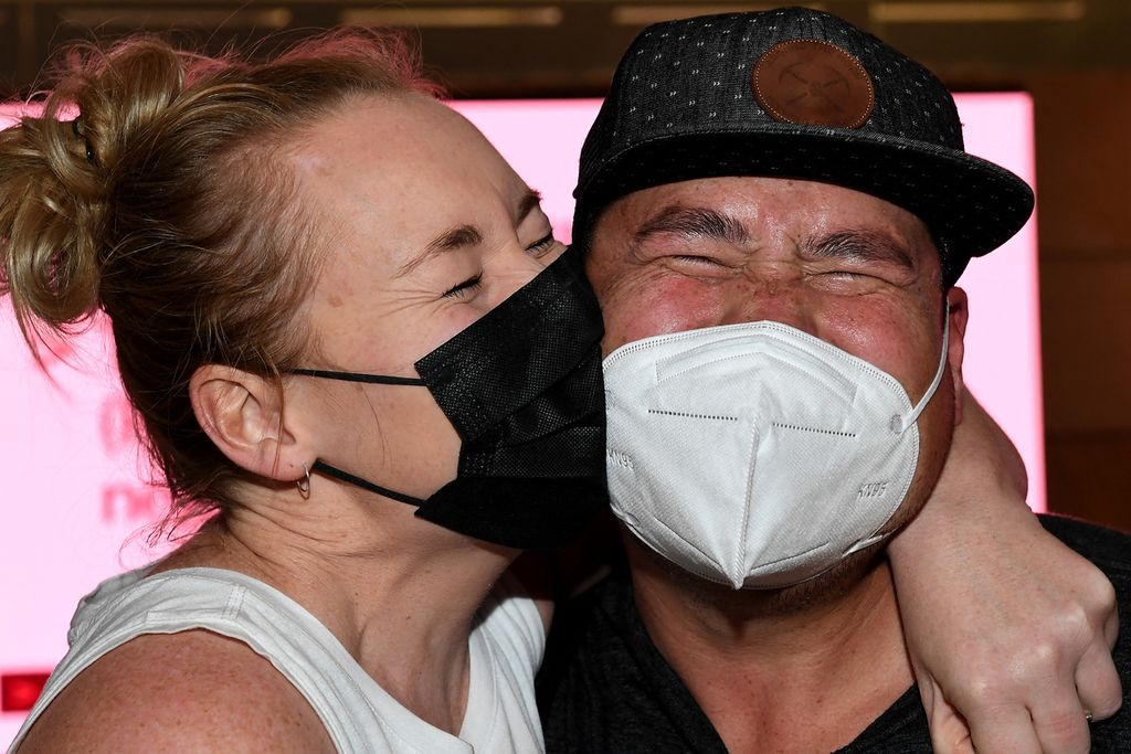 Dua orang anggota keluarga yang sempat berpisah karena pandemi bergembira bersama ketika mereka bertemu di Bandara Internasional Sydney, Australia, Senin (21/2/2022). 