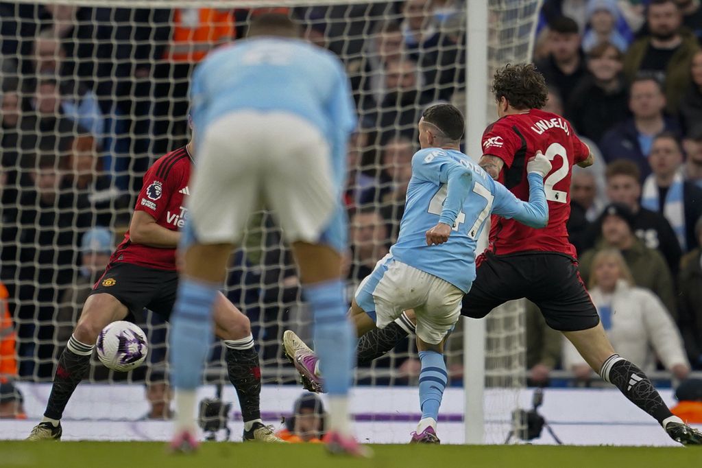 Gelandang Manchester City, Phil Foden, mencetak gol ke gawang Manchester United pada laga Liga Inggris, Minggu (3/3/2024). 
