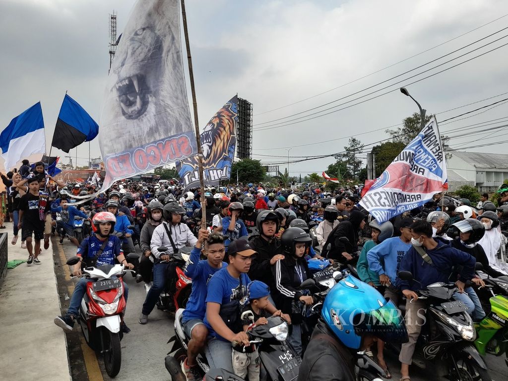 Bendera dan atribut lain menghiasi kegiatan konvoi Aremania atau pendukung tim sepak bola Arema FC saat menyambut tim kesayangan mereka yang baru saja tiba di Malang, Jawa Timur, Senin (18/7/2022).